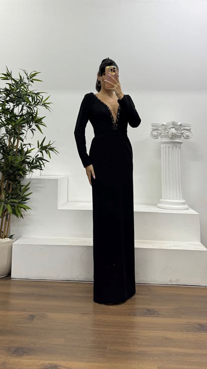 Schwarzes, tief eingefasstes, mit Steinen verziertes Abendkleid in besonderem Design